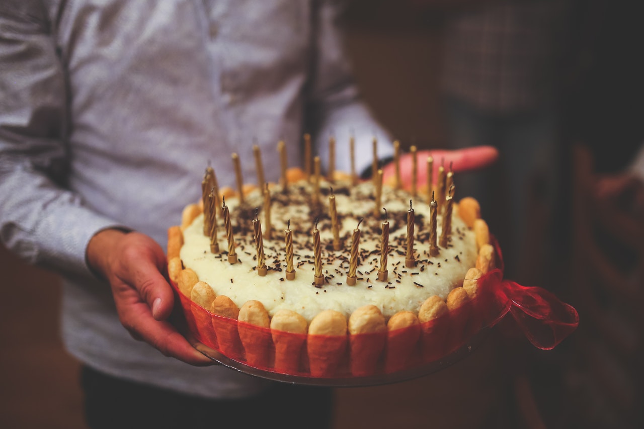 Premium AI Image | Laugh out loud man holding a big birthday cake with  candles